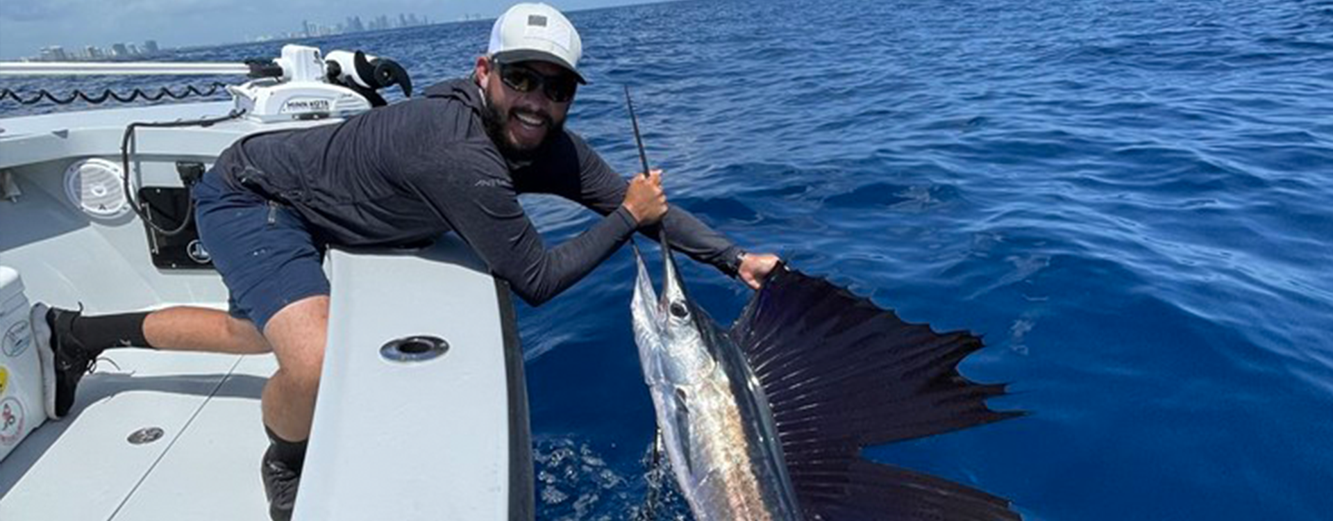 A fisherman aboard Fetched Up Charters proudly shows off his catch from Miami Deep Sea Fishing.