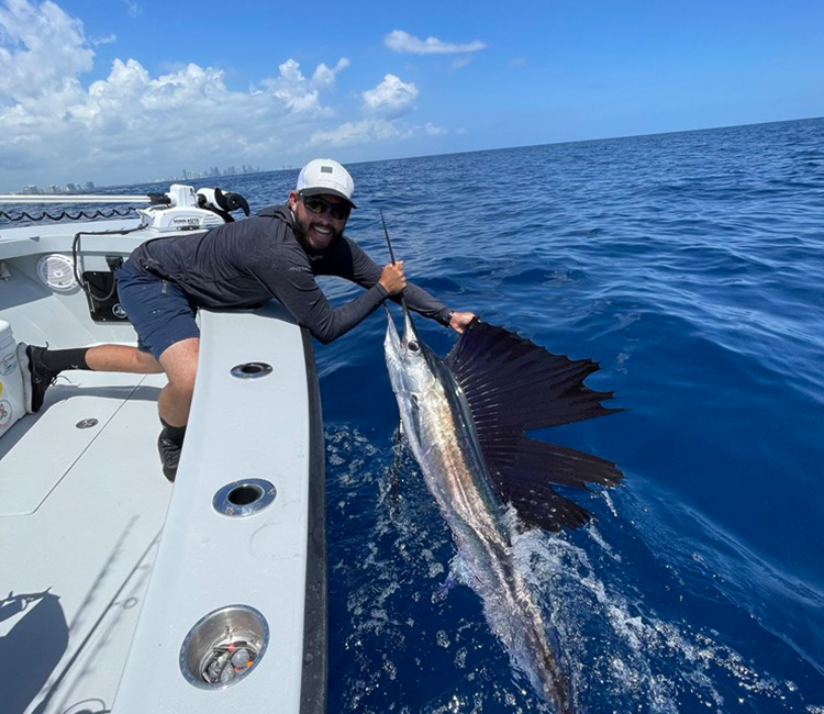 A fisherman aboard Fetched Up Charters proudly shows off his catch from Miami Deep Sea Fishing.