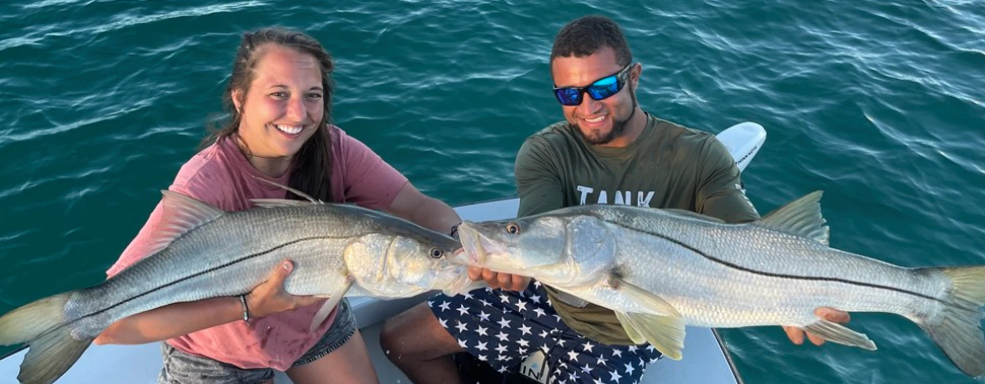 Two anglers aboard Fetched Up Charters display large catches from Miami Offshore Fishing Charters in Miami Beach.