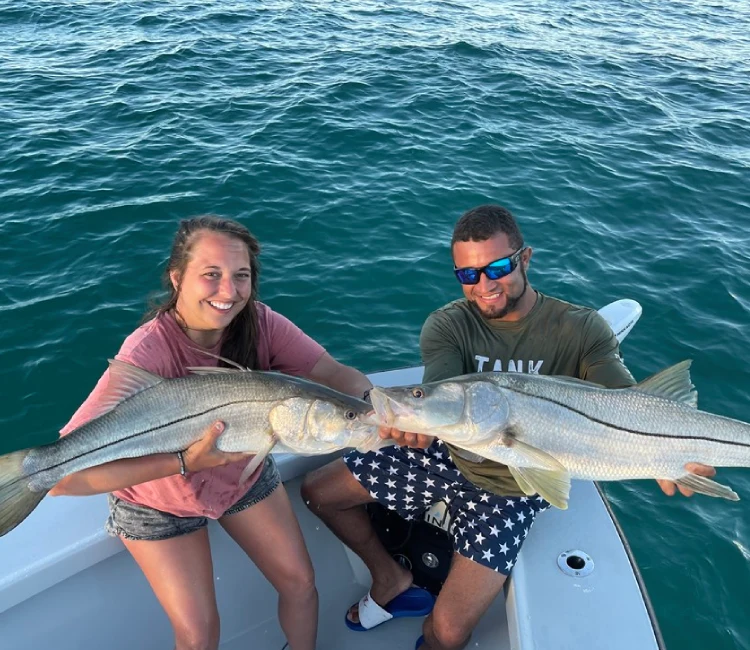 Two anglers aboard Fetched Up Charters display large catches from Miami Offshore Fishing Charters in Miami Beach.